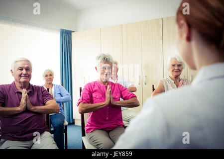 Group of seniors doing exercises with nurse Stock Photo