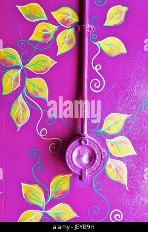 Old unused  electric light switch on wall painted purple with elaborate leaf pattern Stock Photo