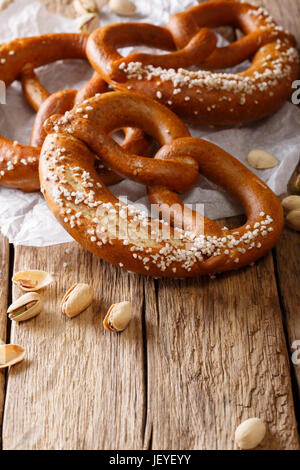 Traditional pretzel with salt and pistachio close-up on the table. Vertical Stock Photo