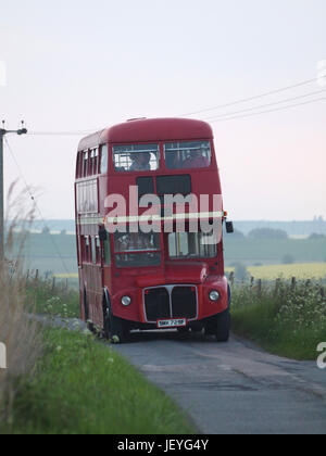 Old traditional red Routemaster bus driving through the Kent countryside. Stock Photo