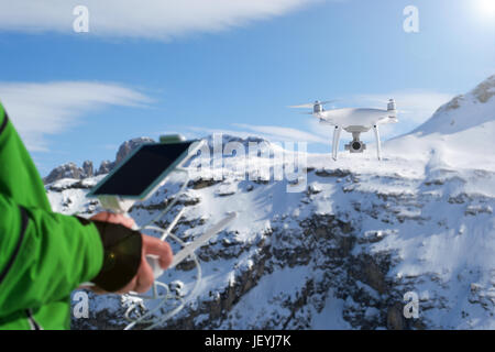 Man hands handling drone in winter Alpine landscape panorama Stock Photo