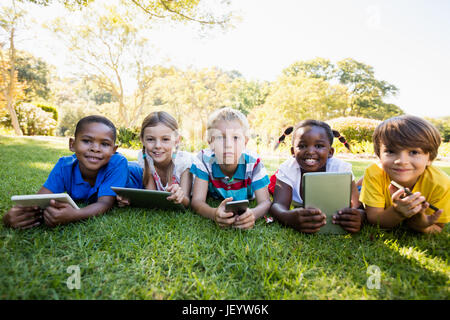 Kids using technology during a sunny day Stock Photo