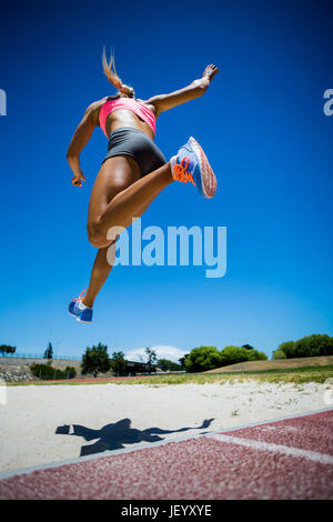 Female athlete performing a long jump Stock Photo