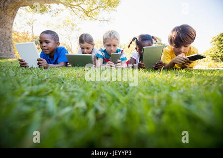 Kids using technology during a sunny day Stock Photo