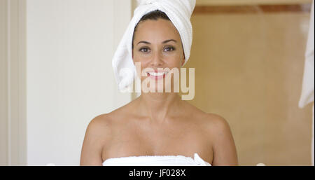 Smiling brunette wearing white towel on head Stock Photo