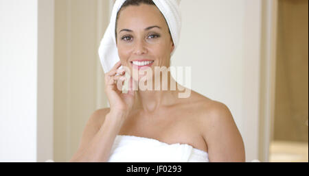 Woman wrapped in towel smiles at camera Stock Photo