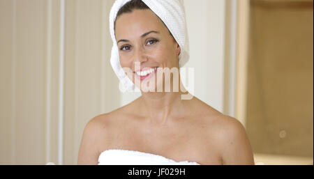 Woman wrapped in towel smiles at camera Stock Photo