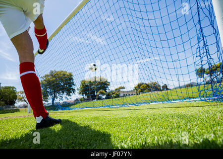 Football player scoring a goal Stock Photo