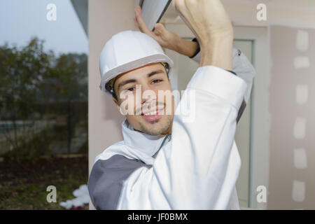 happy builder sets fittings on the window Stock Photo