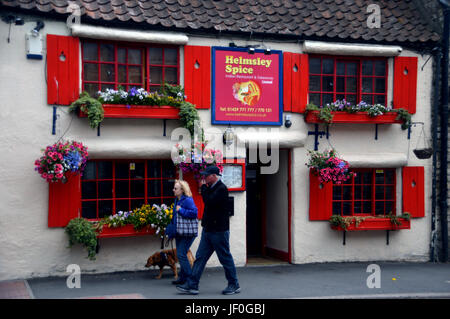 A Couple Walking There Dog Passed Helmsley Spice, Indian Restaurant in the Market Town of Helmsley, Ryedale, North Yorkshire Moors National Park. Stock Photo