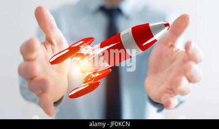 Businessman on blurred background holding red rocket in his hand 3D rendering Stock Photo