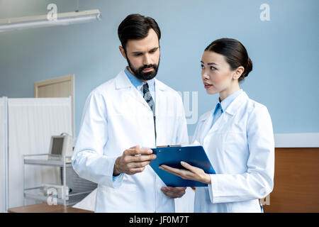 two doctors holding diagnosis and discussing in hospital chamber, caring doctors concept Stock Photo