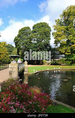 Tourists standing on the footbridge in the Pavilion Gardens, Buxton, Derbyshire, England, UK, Western Europe. Stock Photo