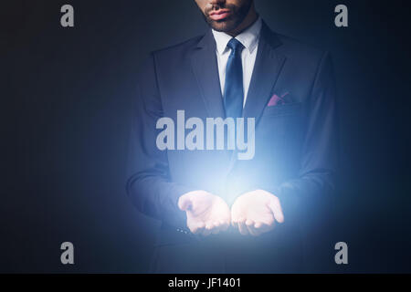 Light radiating from businessman hands. New idea, prime product concept. Stock Photo