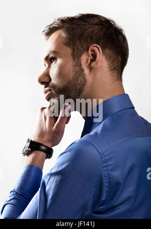 Young businessman thinking about new business ideas. White background, backlight Stock Photo