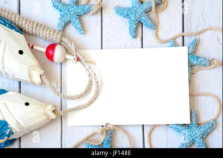 Blank white greeting card with white Starfish and seashells on blue small stone pebbles Stock Photo