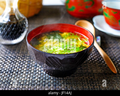 A closeup of a steaming bowl of Japanese miso soup against a dark background. Stock Photo