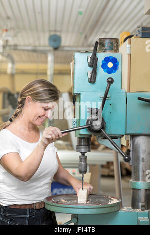 Smiling woman working in workshop Stock Photo