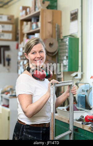 Smiling woman with old window frame Stock Photo