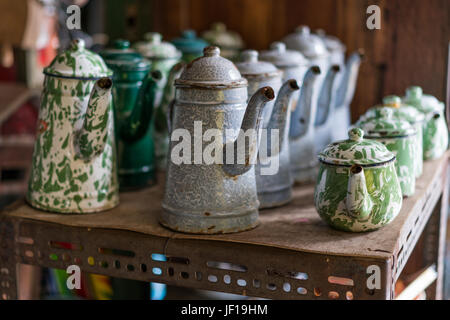 Display of rustic enameled tin coffee pots and tea pots. Stock Photo