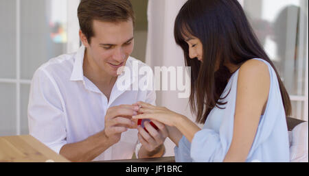 Man fitting ring on finger of girlfriend Stock Photo
