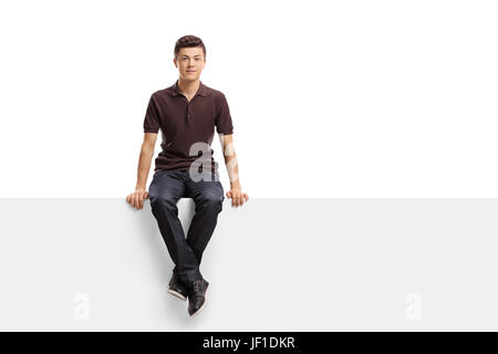 Teenage boy sitting on a panel isolated on white background Stock Photo