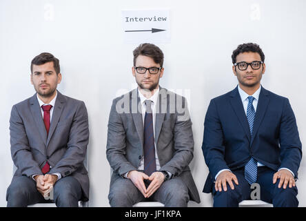 businessmen in suits sitting on chairs at white waiting room. business meeting Stock Photo