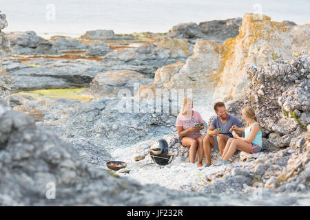 Family playing cards on rocks Stock Photo