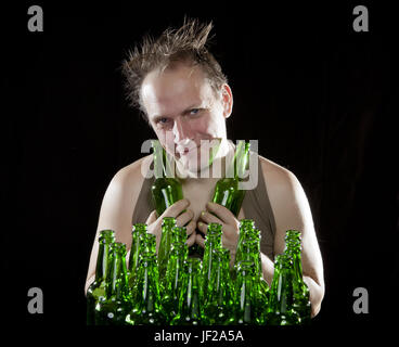 The happy tipsy man near empty beer bottles Stock Photo