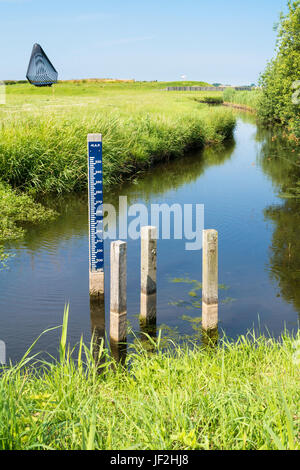 Water level staff gauge in ditch in polder Schokland, Noordoostpolder, Flevoland, Netherlands Stock Photo