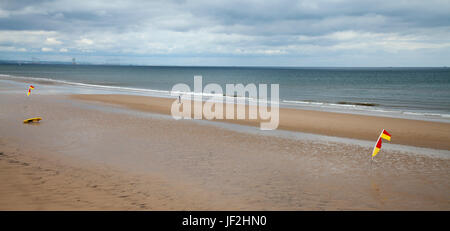 The red and yellow safety flags flying on Saltburn beach,England,UK Stock Photo