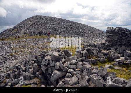 Lone Male Hill Walker on the Summit of Scottish Mountain Corbett Beinn an Oir (The Paps of Jura) Scotland, UK. Stock Photo