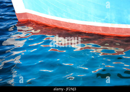Colorful wooden boat bow and its reflection in the sea Stock Photo