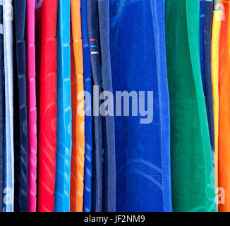 Different colored beach towels hanging on display in a shop, detail Stock Photo