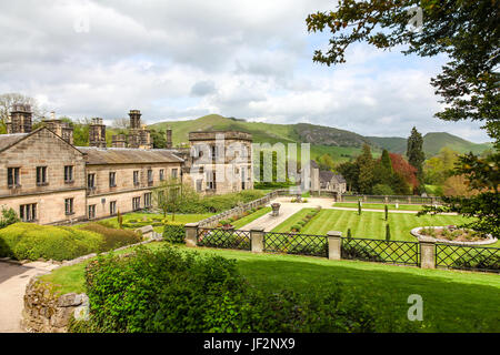 Ilam Hall and gardens with Church Of The Holy Cross in the background, Ilam, Staffordshire, England, UK Stock Photo