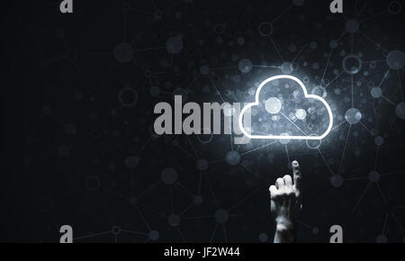 Mans hand pointing to light cloud on dark background Stock Photo