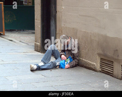 zombie drug spice begging homeless unemployed man lying  on the street unconscious Stock Photo