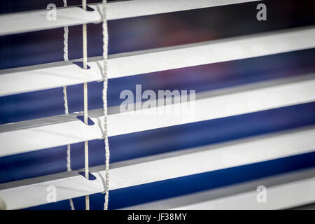 White venetian blinds close-up in the evening. Stock Photo