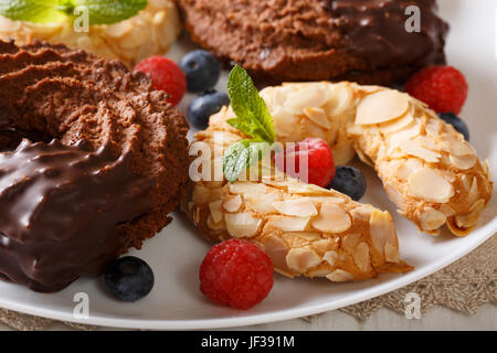Beautiful horseshoe cakes with chocolate and almonds close-up on a plate. horizontal Stock Photo