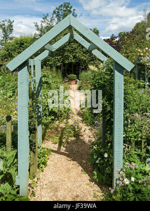 Green painted wooden arch arbour over garden path, Barnsdale Gardens, Oakham, Rutland, UK Stock Photo