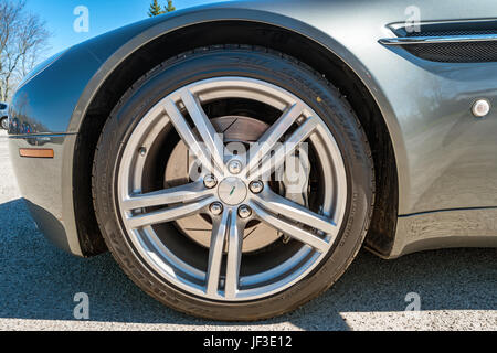 One wheel with rim and tire of an Aston Martin V8 Vantage Coupe luxury sports car parked in a parking lot in Hamilton, Ontario. Stock Photo