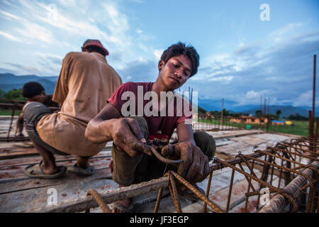 Young man working with rebar when building a home in Nuwakot District, Nepal Stock Photo