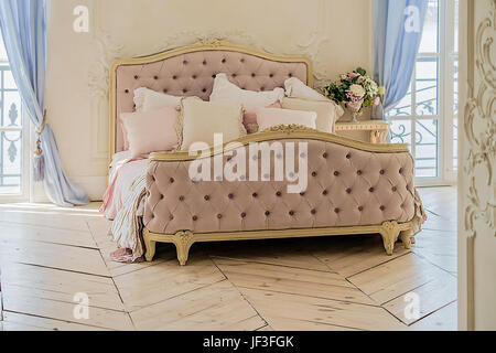 Vintage bed with the pillows in luxury clean bright white bedroom interior Stock Photo