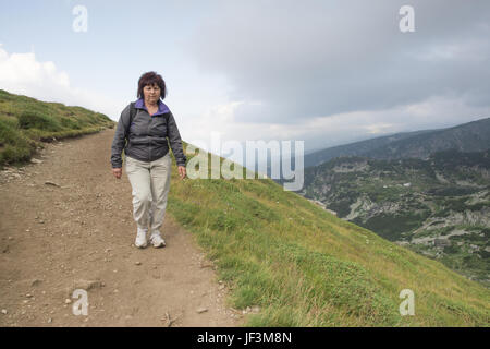 Senior woman walking in the mountain Stock Photo