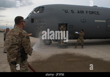 Chief Master Sgt. Peter Speen, the 455th Air Expeditionary Wing command chief, hoses down Col. Rebecca Sonkiss, the 455th AEW vice commander, at Bagram Airfield, Afghanistan, May 16, 2017. Sonkiss conducted her fini flight out of Bagram Airfield. The fini flight is a time-honored military aviation tradition marking the last flight of a commander’s tour. (U.S. Air Force photo by Staff Sgt. Benjamin Gonsier) Stock Photo