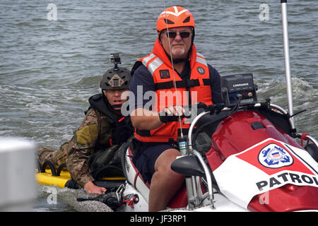 Master Sgt. James Henderson, 181st Weather Flight special operations weatherman, rides with a U.S. Coast Guard Auxiliary member to drop off his parachute gear after a deliberate water drop into Lake Worth in Fort Worth, Texas, May 20, 2017. The mission allowed 12 service members to parachute out of a C-130 Hercules from an altitude of 1000 feet into Lake Worth using MC-6 parachutes. (Texas Air National Guard photo by Staff Sgt. Kristina Overton)