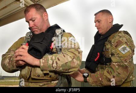 Staff Sgt. Curtis Humphreys, with the assistance of Master Sgt. James Henderson, 181st Weather Flight special operations weathermen, adjusts his parachute gear prior to a deliberate water drop into Lake Worth in Forth Worth, Texas,  May 20, 2017. The jump was part of an exercise to train on tactical skills when operating in hostile and denied territories.(Texas Air National Guard photo by Staff Sgt. Kristina Overton)