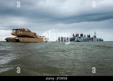 An M1A1 Abrams tank is offloaded from USNS SGT William R. Button onto a ...