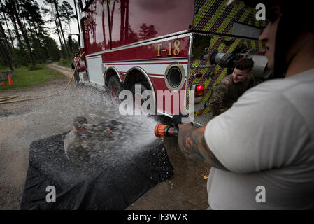 Senior Airman Frank Boniello, 23d Civil Engineer Squadron firefighter performs an initial decontamination of Senior Airman Jonah Phillips, 822d Base Defense Squadron fireteam member during a simulated explosives and hazardous material scenario, May 24, 2017, at Moody Air Force Base, Ga. The exercise simulated initial responses from first responders who then contacted other appropriate units after assessing the potential threat while also assisting the simulated victims of hazardous materials. (U.S. Air Force photo by Airman 1st Class Daniel Snider) Stock Photo