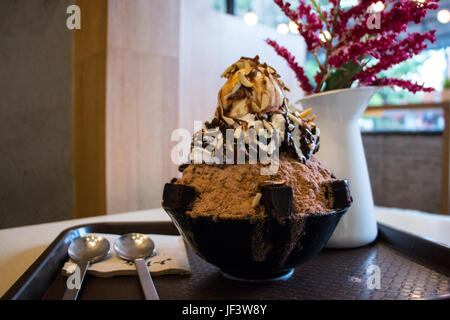 Blurred image of a flavor full delicious chocolate bingsu on top with vanilla ice cream with chocolate syrup. Bingsu is a korean dessert. Stock Photo